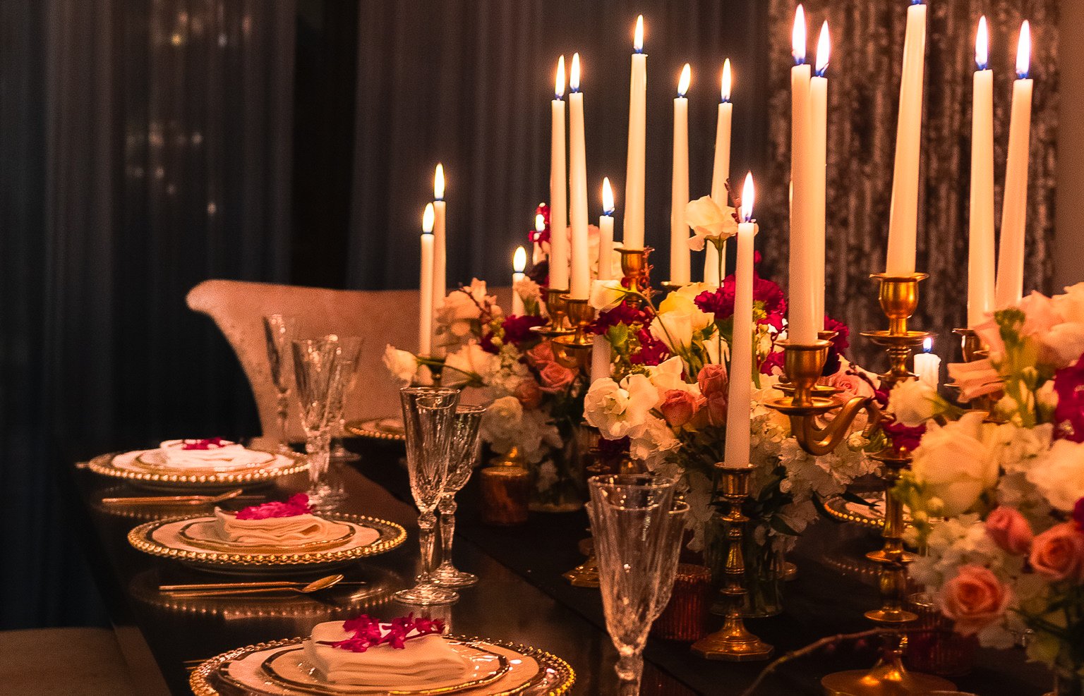Candlelit tablescape with florals and gold place settings