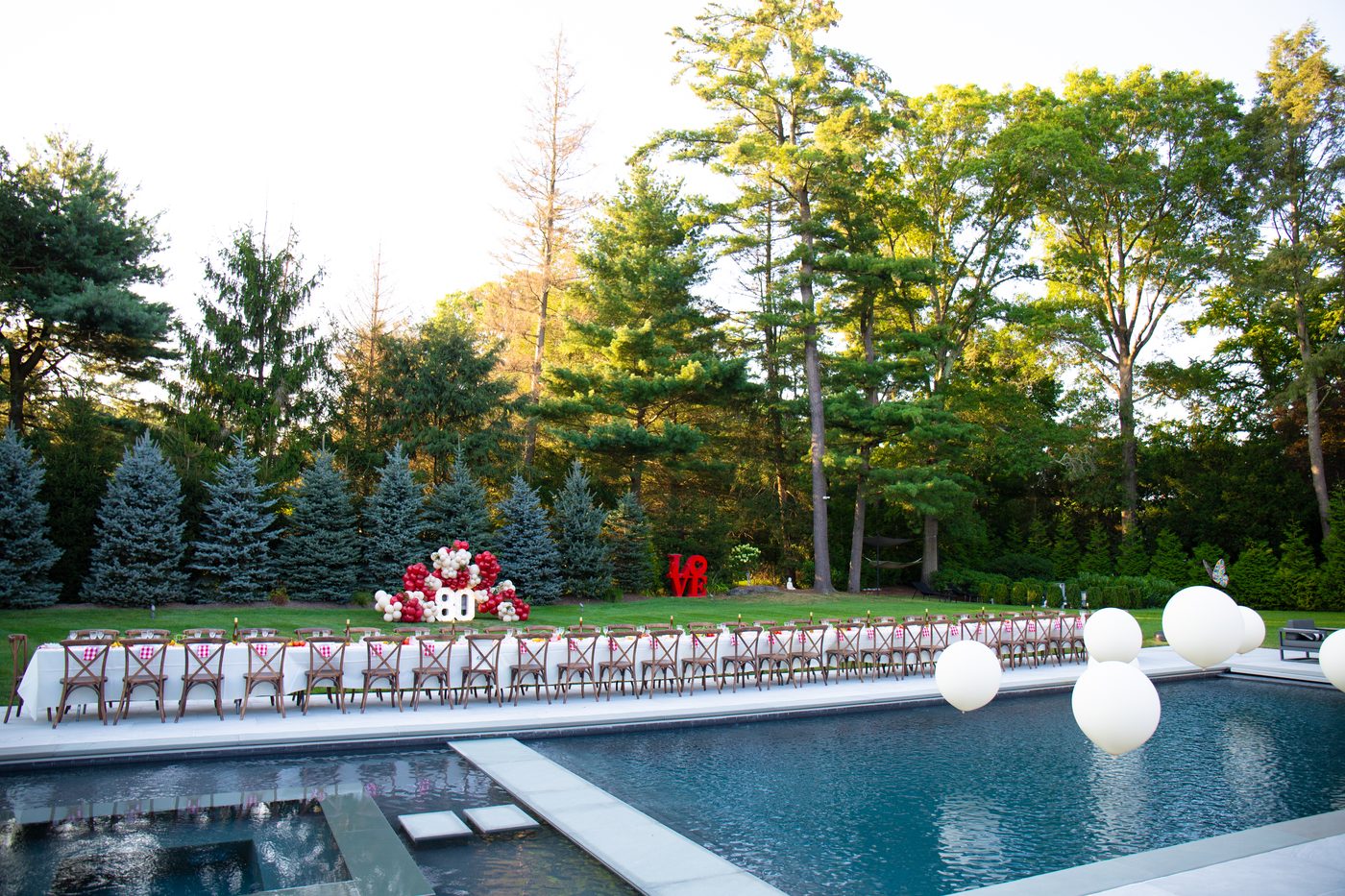 Backyard celebration at dusk, string lights over the pool